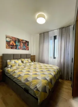 Namještena spavaća soba sa bračnim krevetom, umjetničkom slikom i prozorom sa zavjesama. - image 7