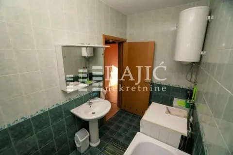 Small bathroom with a sink, water heater, and washing machine. - image 16