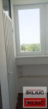 Zastakljeni balkon sa pogledom na zelenilo i okruženje. - image 12