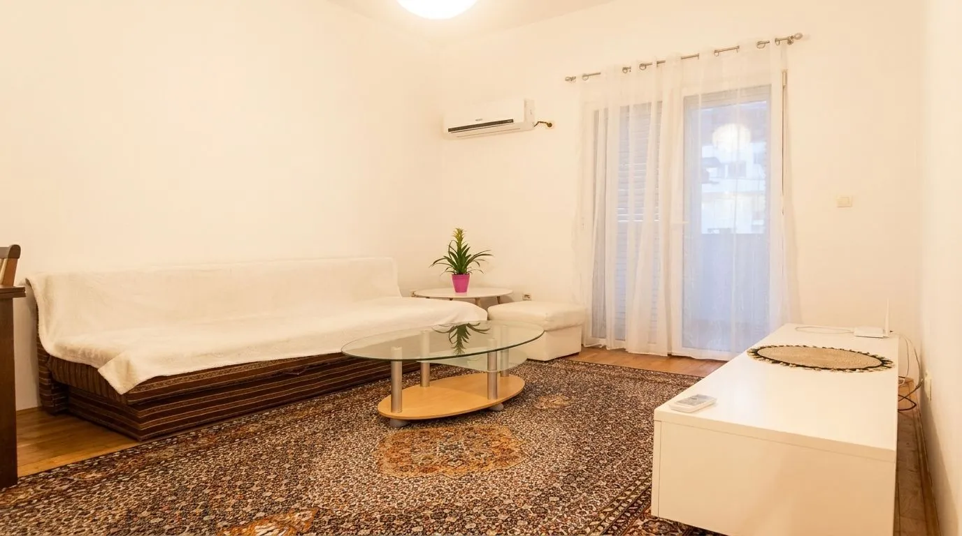 Living room with a sofa, glass coffee table, and access to the terrace.