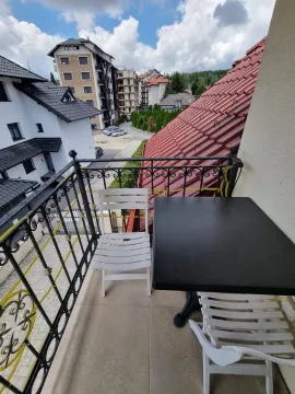 Manji balkon sa stolom i stolicama i pogledom na naselje. - image 8