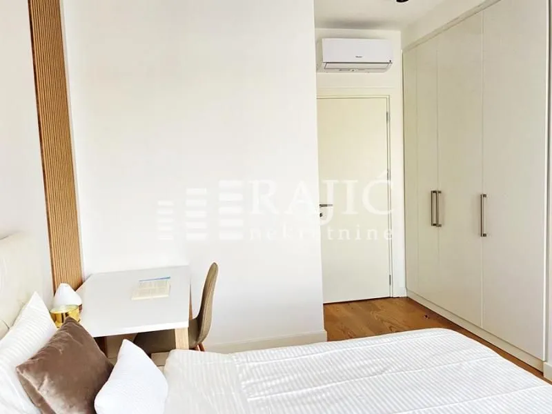Bright bedroom with a double bed, desk, and built-in wardrobe.
