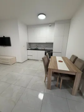 Modern kitchen with a dining area and white cabinets. - image 4