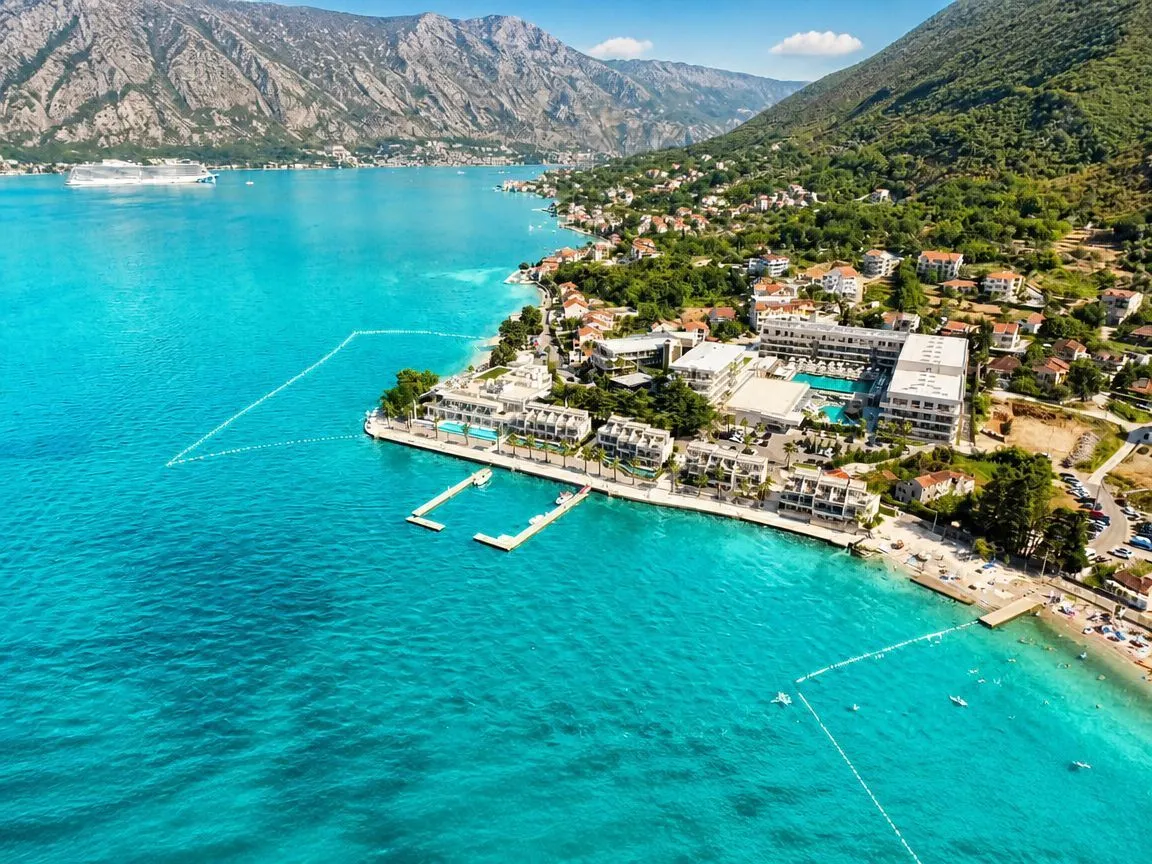 Pogled iz vazduha na obalu sa zgradama i plavim morem.