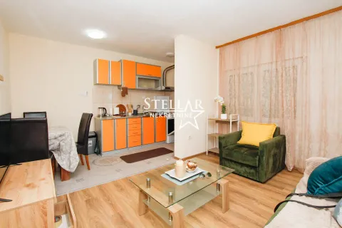 Living room with dining area and connected kitchen in orange tones. - image 4