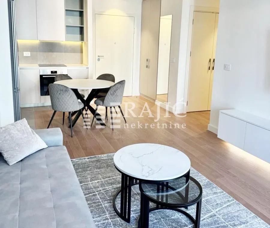 Modern living room with a dining area and kitchen in the background.