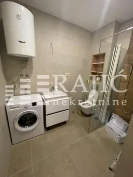 Modernly equipped bathroom with a shower cabin, sink, and washing machine. - image 6