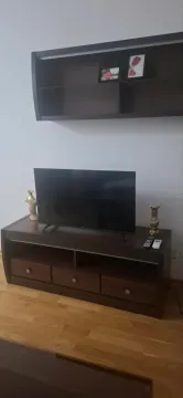 Dnevna soba sa TV komodom i policom na zidu. - image 4