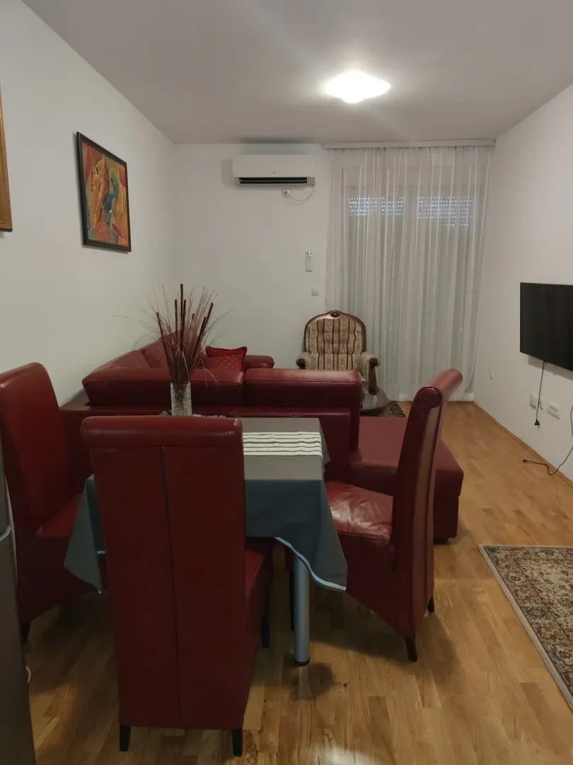 Living room with a red leather sofa set and a dining table.