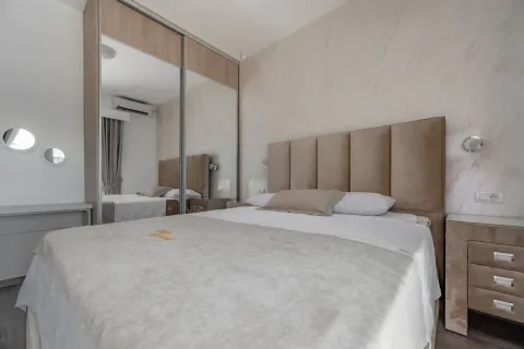Bedroom with a double bed, upholstered headboard, and a large wardrobe with mirrored sliding doors. - image 21
