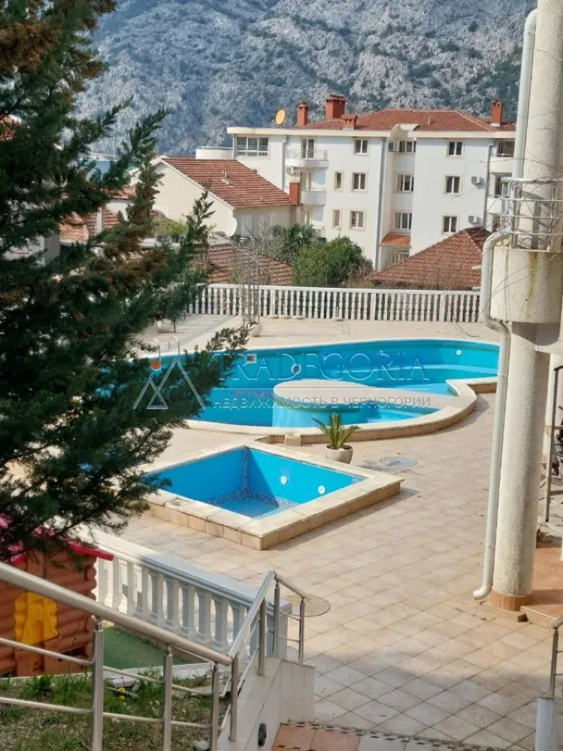 Pogled na bazen i dvorište zgrade sa okolnim objektima.