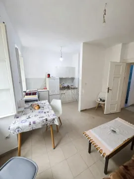 Living room with a dining area and a small kitchen in the background. - image 7
