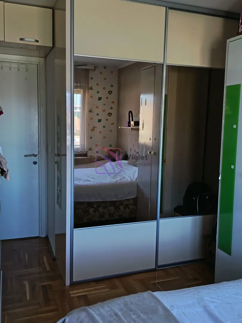 Spavaća soba sa velikim ugradnim garderoberom sa ogledalima.