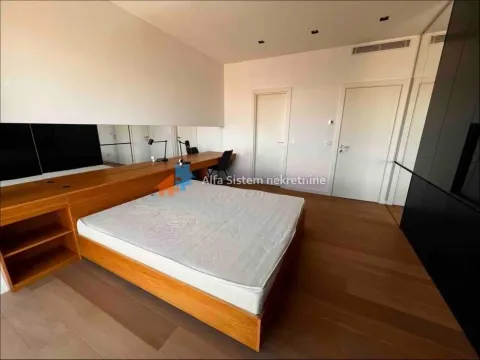 Prostrana spavaća soba sa bračnim krevetom, drvenim podom i ugradnim ormarom. - image 11