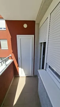 Pogled na prostrani balkon sa spoljnim vratima i prozorom sa roletnama. - image 9