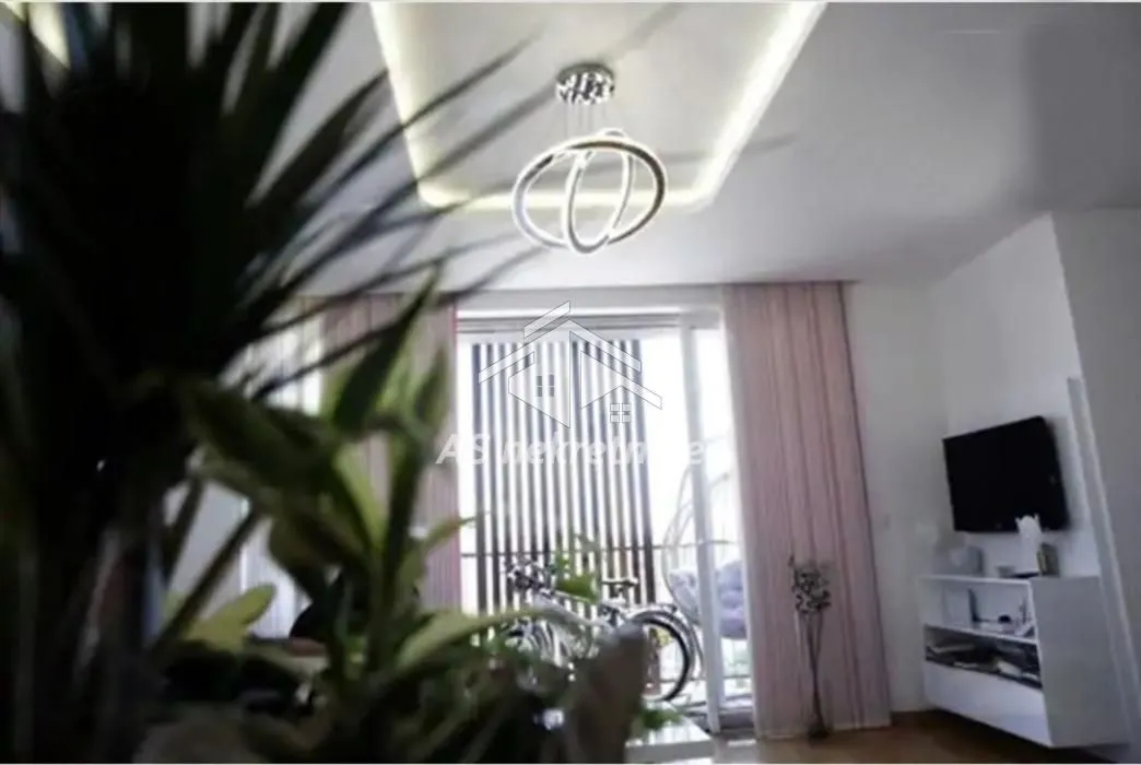 Living room with a modern chandelier and access to the terrace.