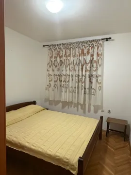 Spavaća soba sa bračnim krevetom i prozorom sa zavjesama. - image 2