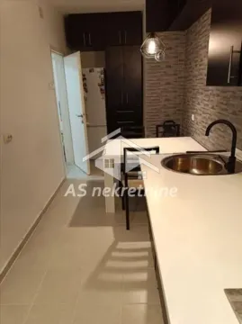 Smaller kitchen with dark cabinets and a dining table. - image 5