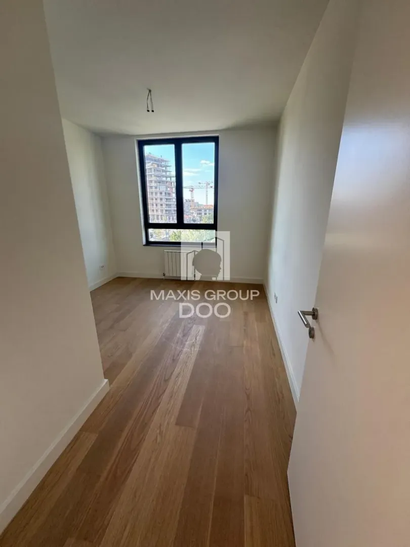 Empty room with wooden flooring and a window.