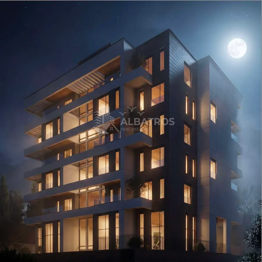 Night view of a modern residential building with illuminated windows and terraces.