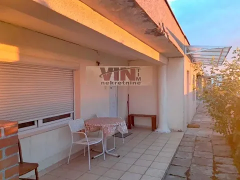 Covered terrace with a table and chairs in front of the house. - image 12