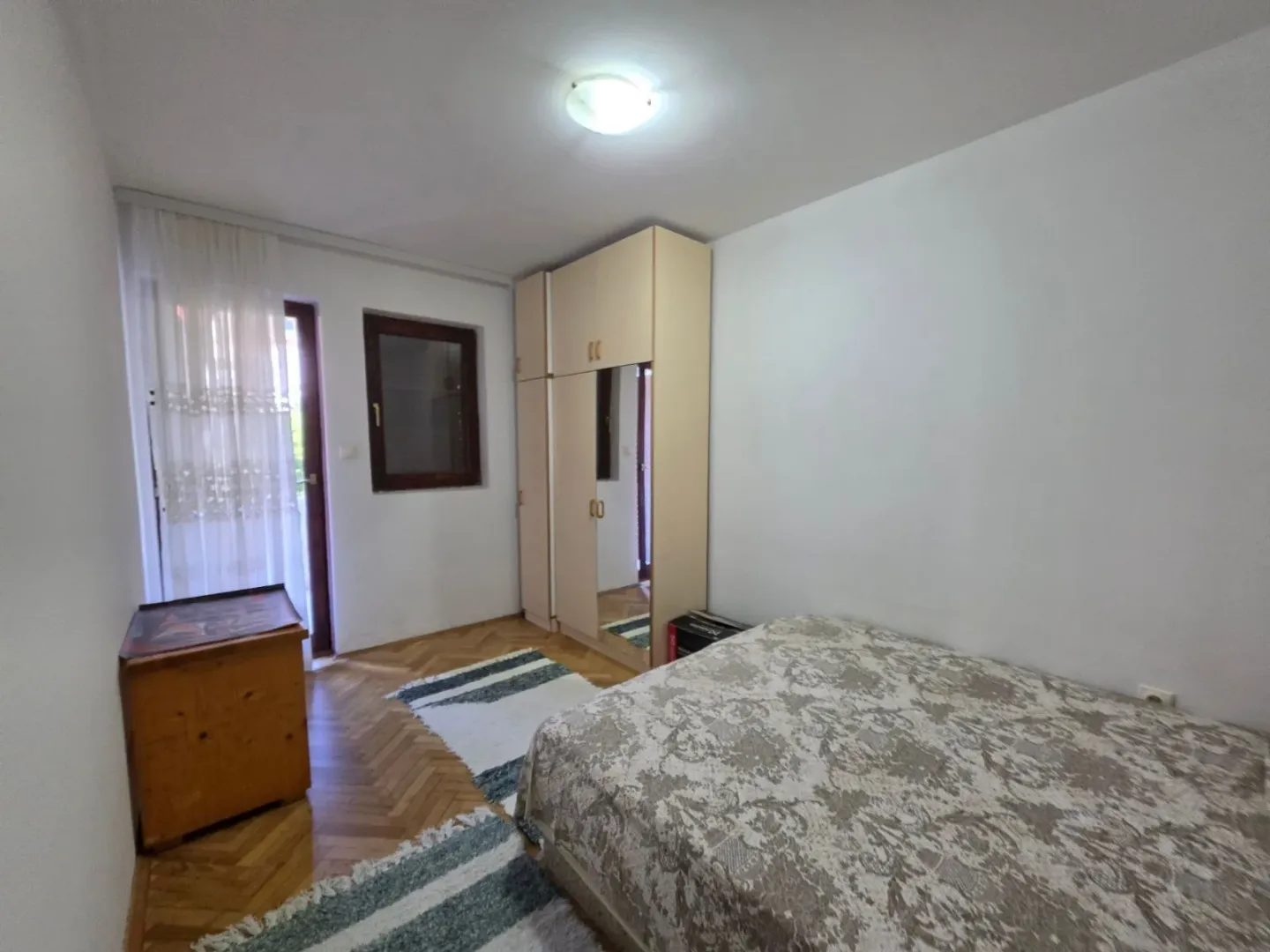 Furnished bedroom with a double bed, wardrobe, and terrace access.