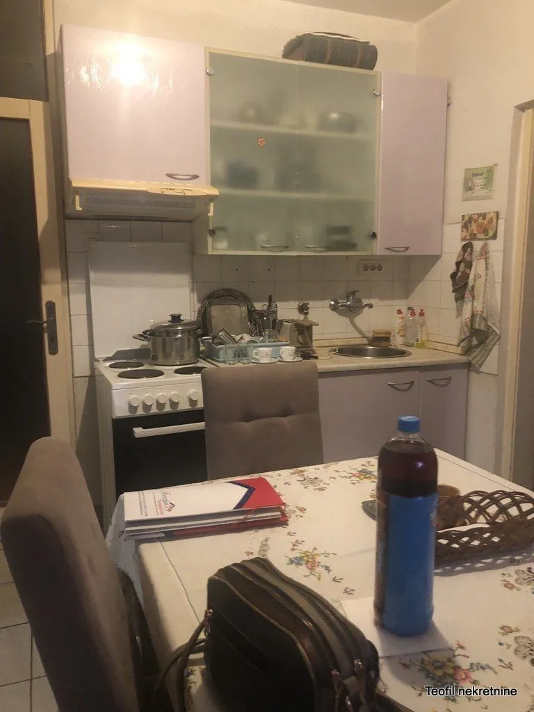 Kuhinja sa trpezarijskim stolom i osnovnim elementima.