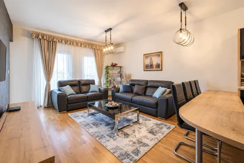 Spacious living room with a sofa set, coffee table, and dining area. - image 12
