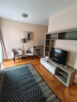 Living room with seating furniture, TV unit, and parquet flooring. - image 10
