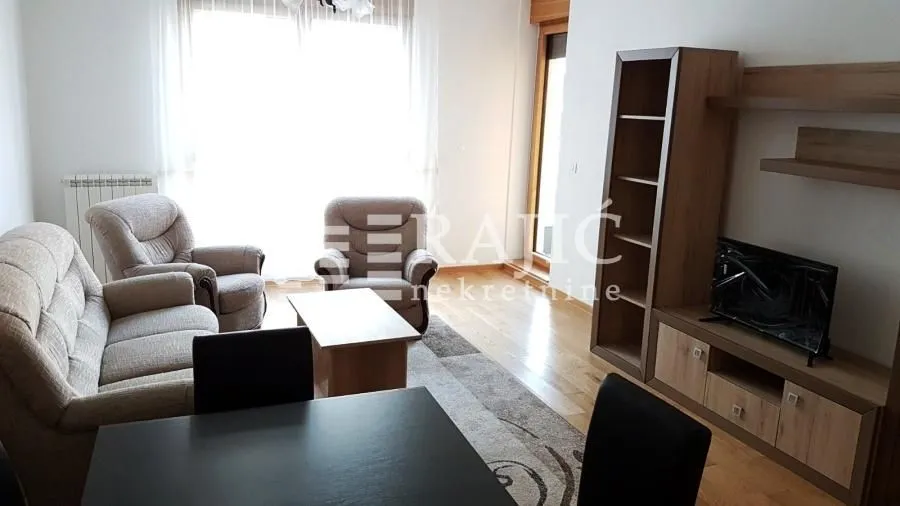 Living room with sofa set, coffee table, and TV unit.
