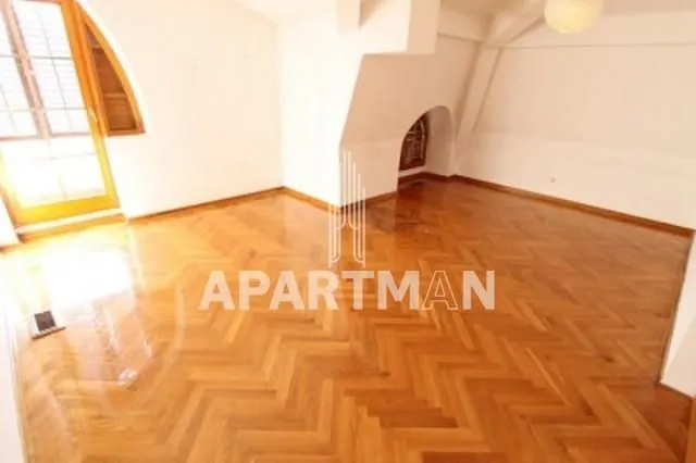 Empty room with parquet flooring and balcony doors.