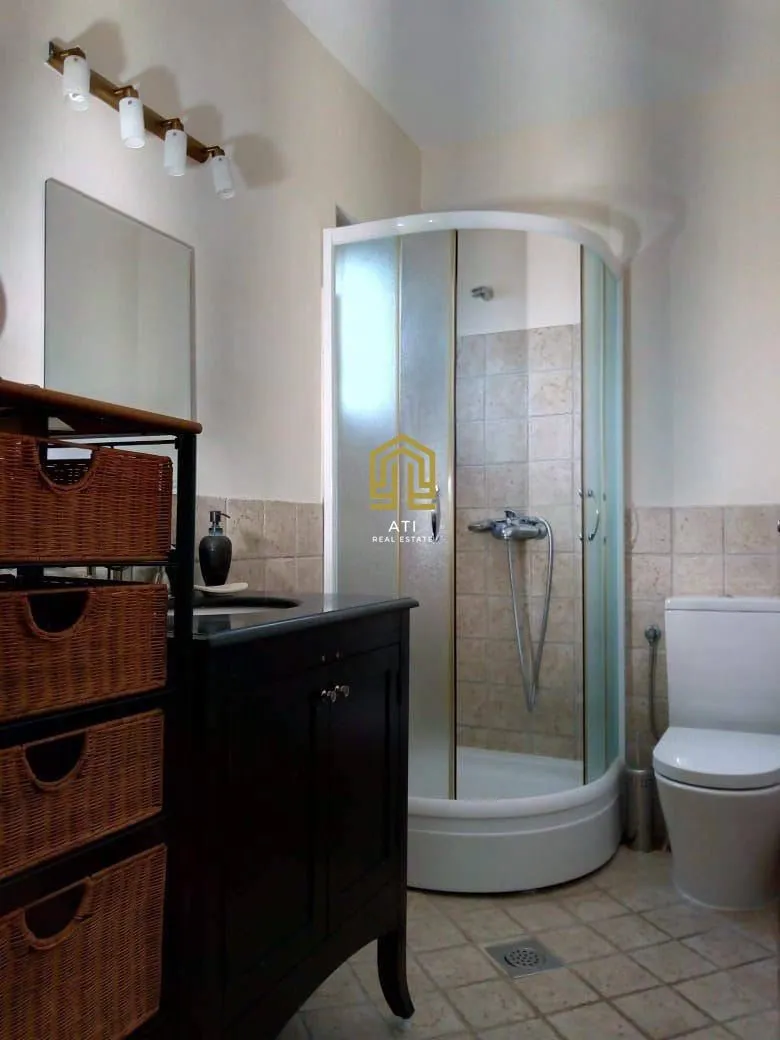 A clear bathroom with a shower cabin, vanity, and toilet.