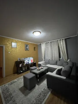 Dnevna soba sa sivom ugaonom garniturom, klub stolom i televizorom. - image 7