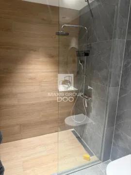 Moderna tuš kabina sa staklenom pregradom i drvenim pločicama. - image 18