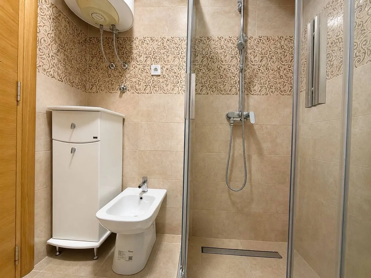 Modernly equipped bathroom with a walk-in shower and bidet.