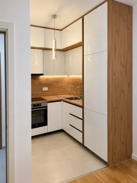 Modern kitchen with white cabinetry and wood-grain details. - image 3