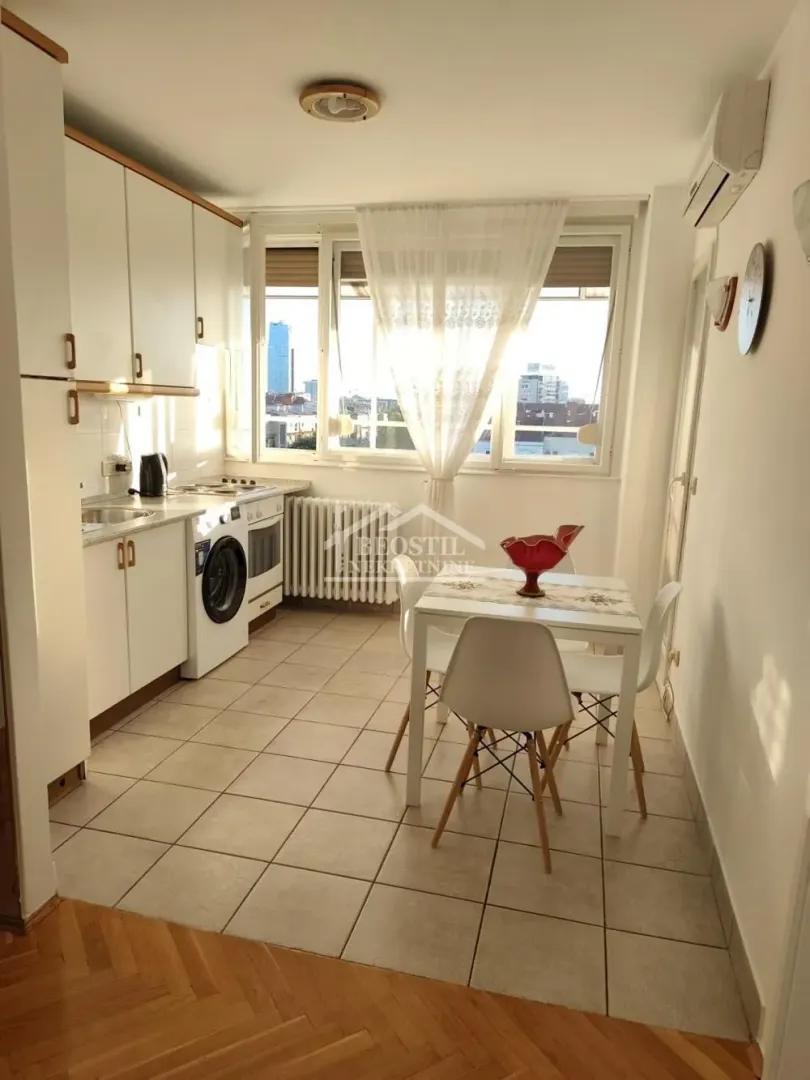 Kitchen with a dining area and a window overlooking the city.