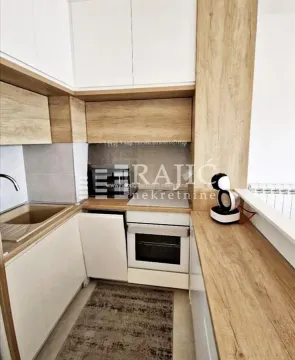 Small kitchen with wooden elements and white upper cabinets. - image 4