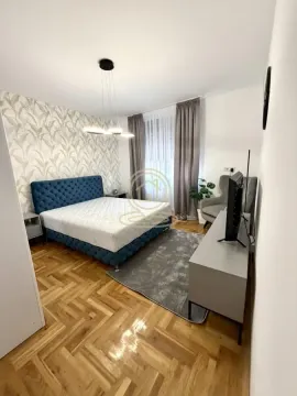 Furnished bedroom with a double bed, TV console, and a rug. - image 6