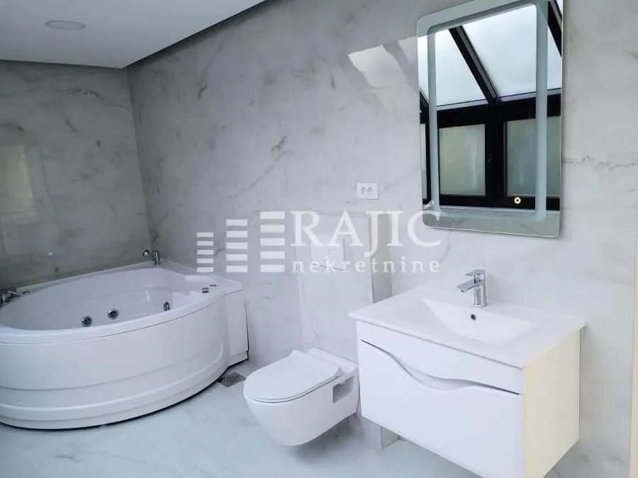 Modern bathroom with a bathtub, sink, and built-in sanitary ware.