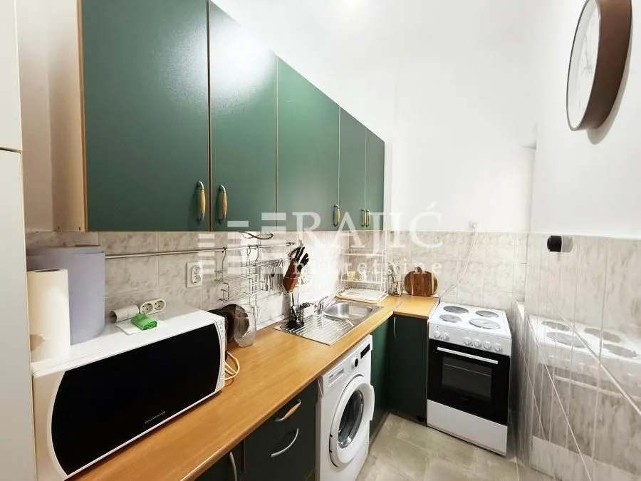 Smaller kitchen with green cabinets and built-in appliances.