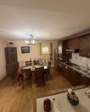 Dining area connected to a kitchen with wooden cabinetry and a dining table. - image 2