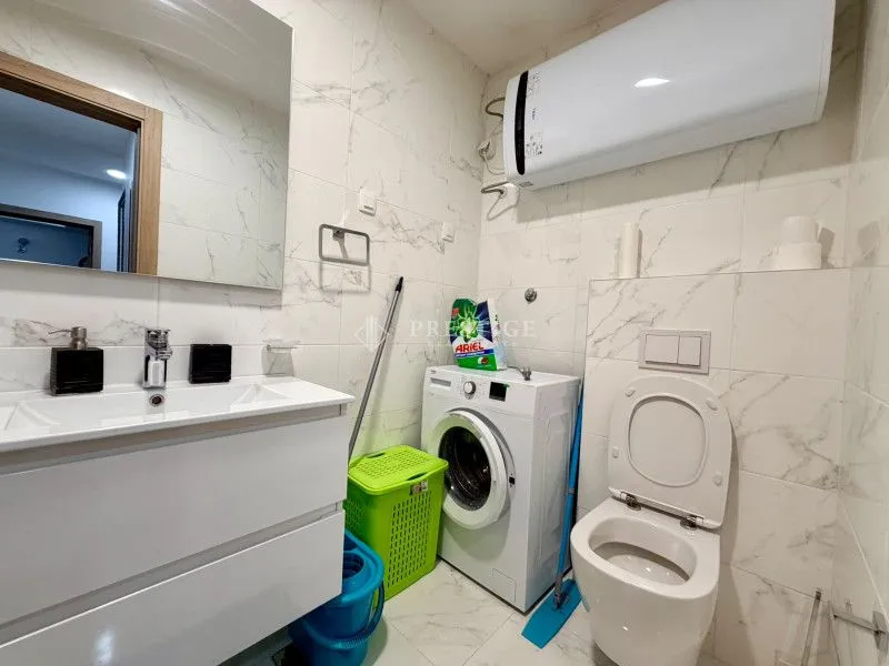 Modern bathroom equipped with a washing machine and toilet.