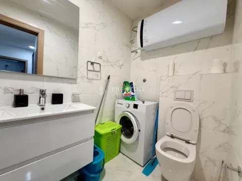 Modern bathroom equipped with a washing machine and toilet. - image 11