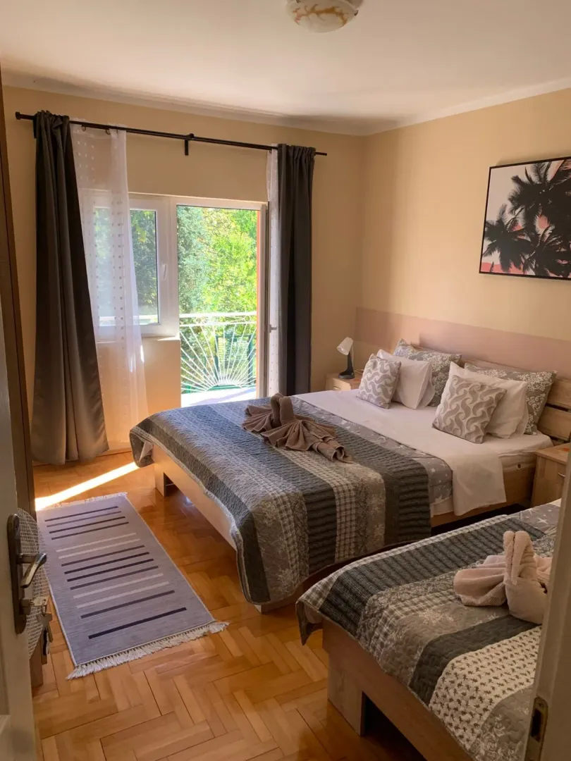 Furnished bedroom with a double bed, a single bed, and access to the terrace.
