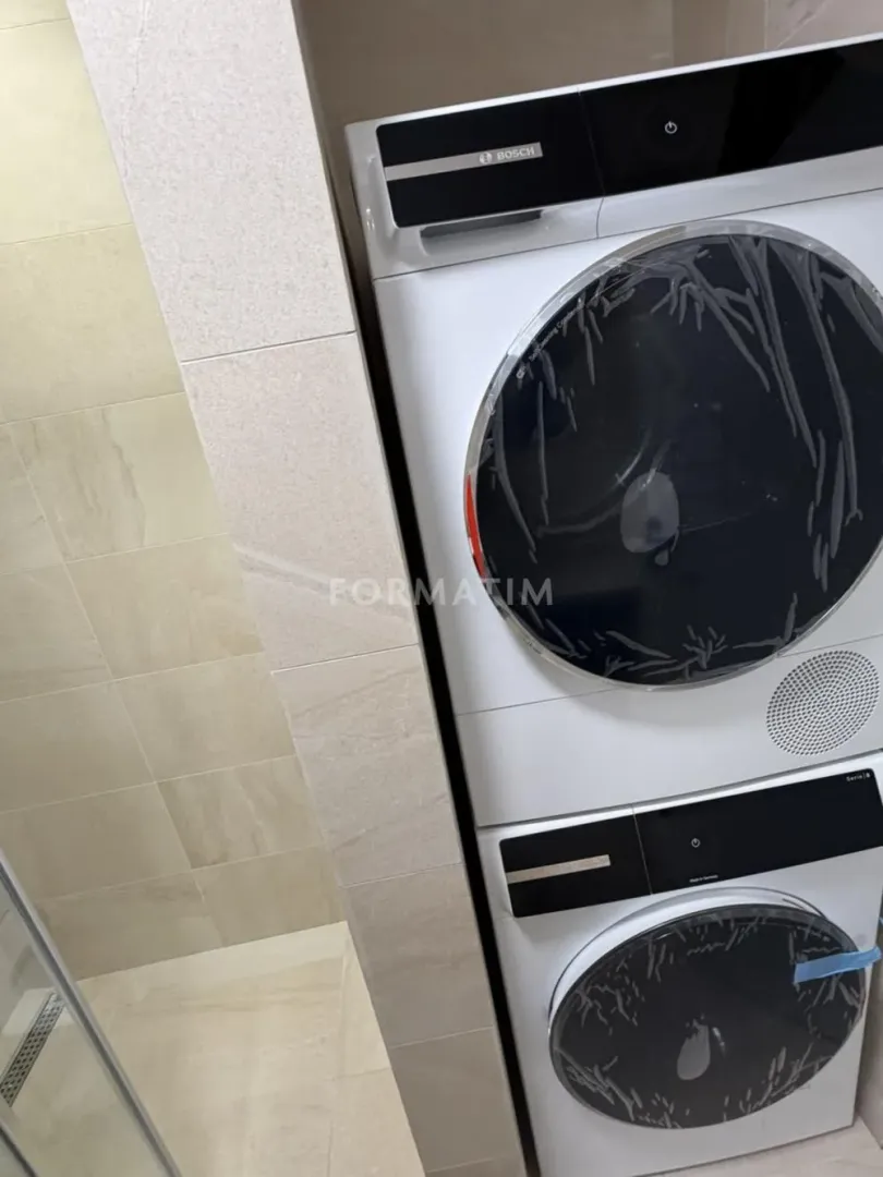 Bathroom with installed washing machine and dryer.