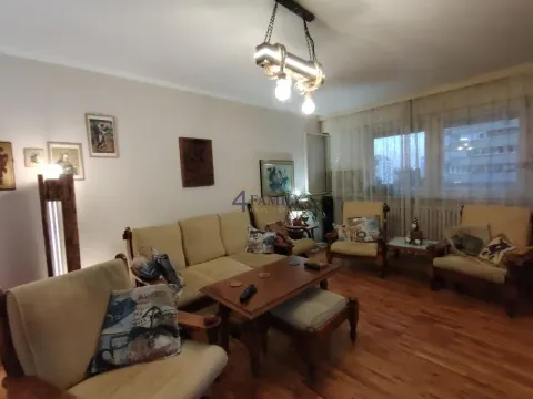Dnevna soba sa garniturom za sedenje, drvenim podom i slikama na zidu. - image 3