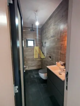 Pogled na moderno opremljeno kupatilo sa tuš kabinom i umivaonikom. - image 19