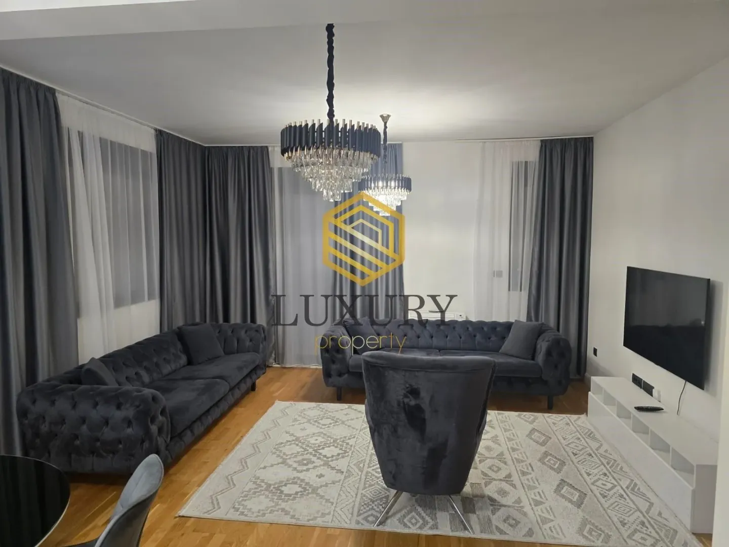 Modern and spacious living room with sofa set and large chandeliers.