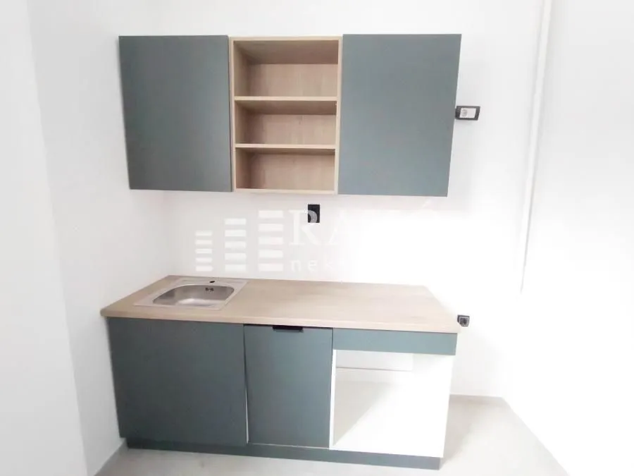 Smaller kitchen with cabinetry and a sink.